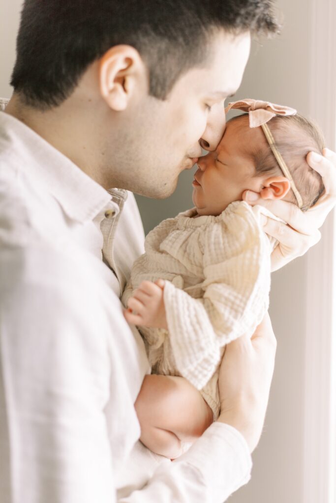 in home newborn photos dad kissing baby