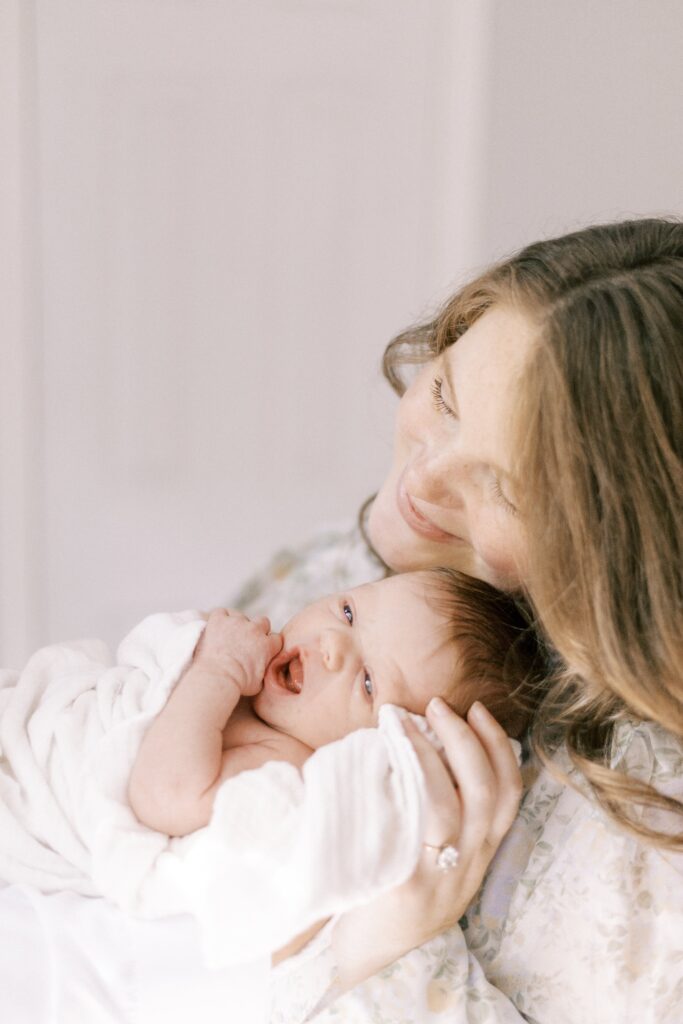 mom snuggling newborn baby