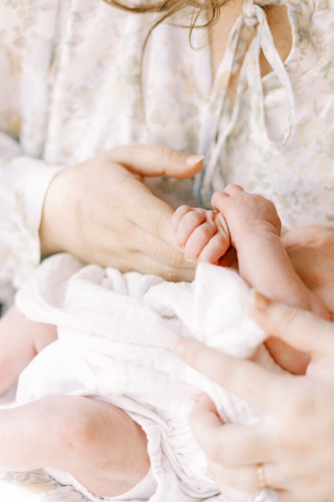 newborn baby holding mom's hand