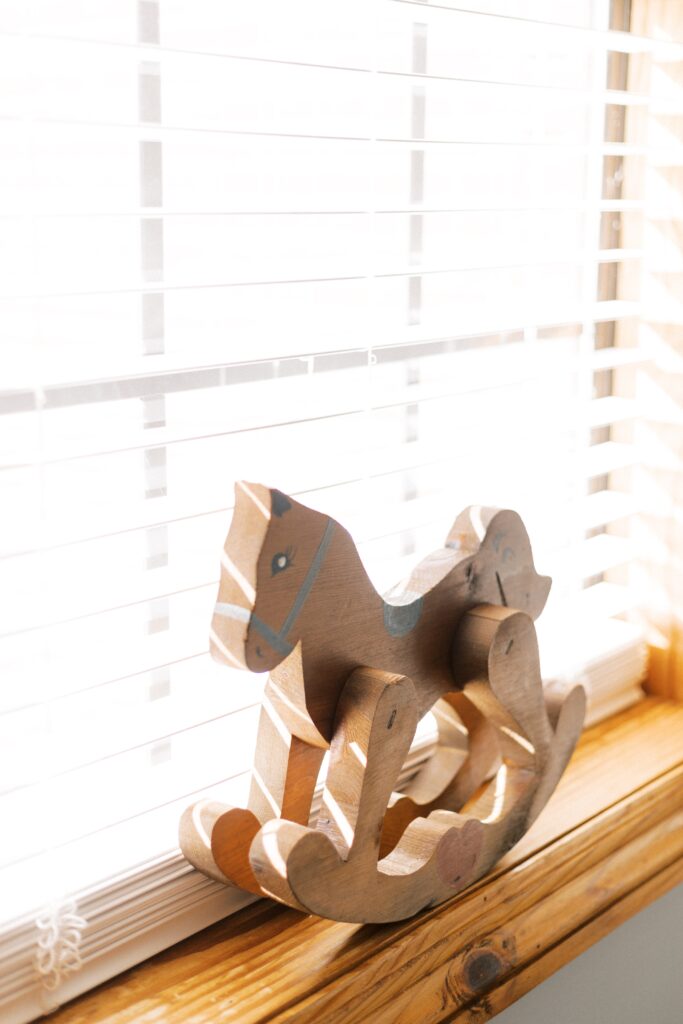 wooden rocking horse in window of nursery