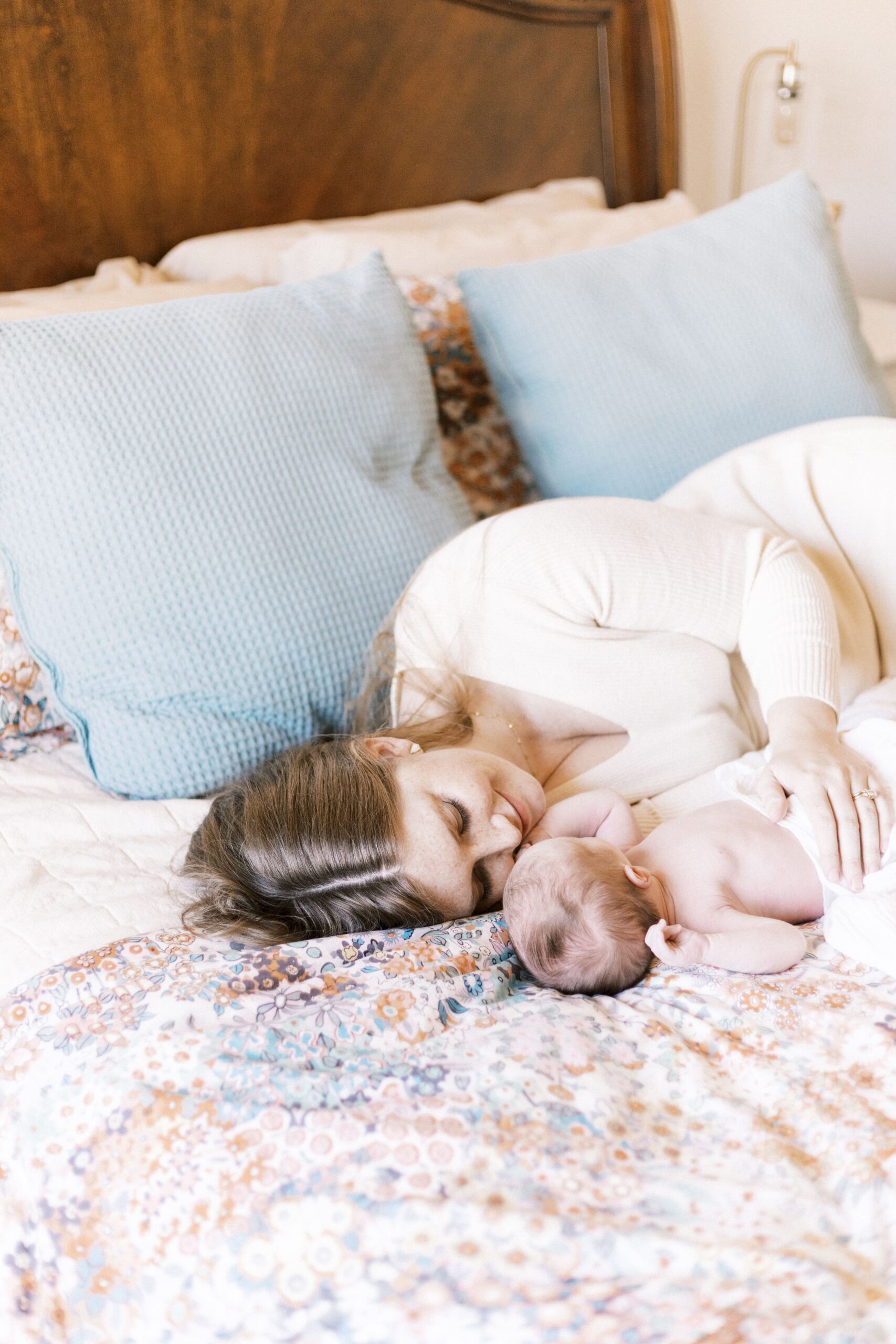 mom and baby laying in bed for relaxed in-home newborn photos