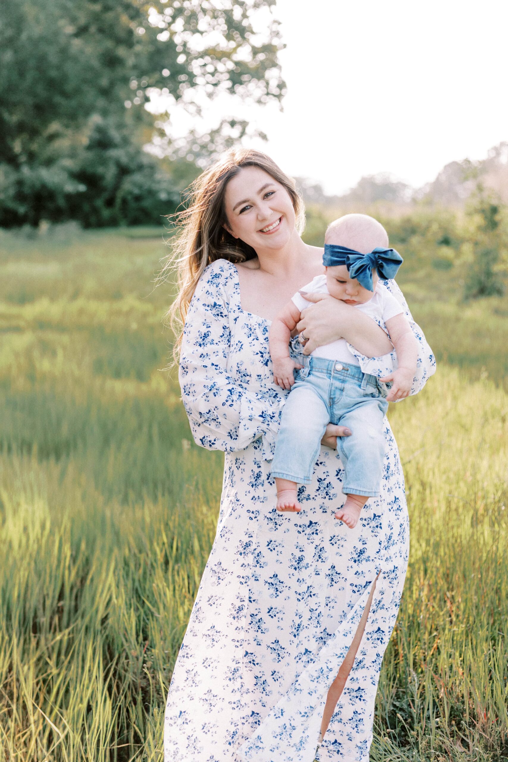 mom holding baby in field in peoria illinois during family photographs