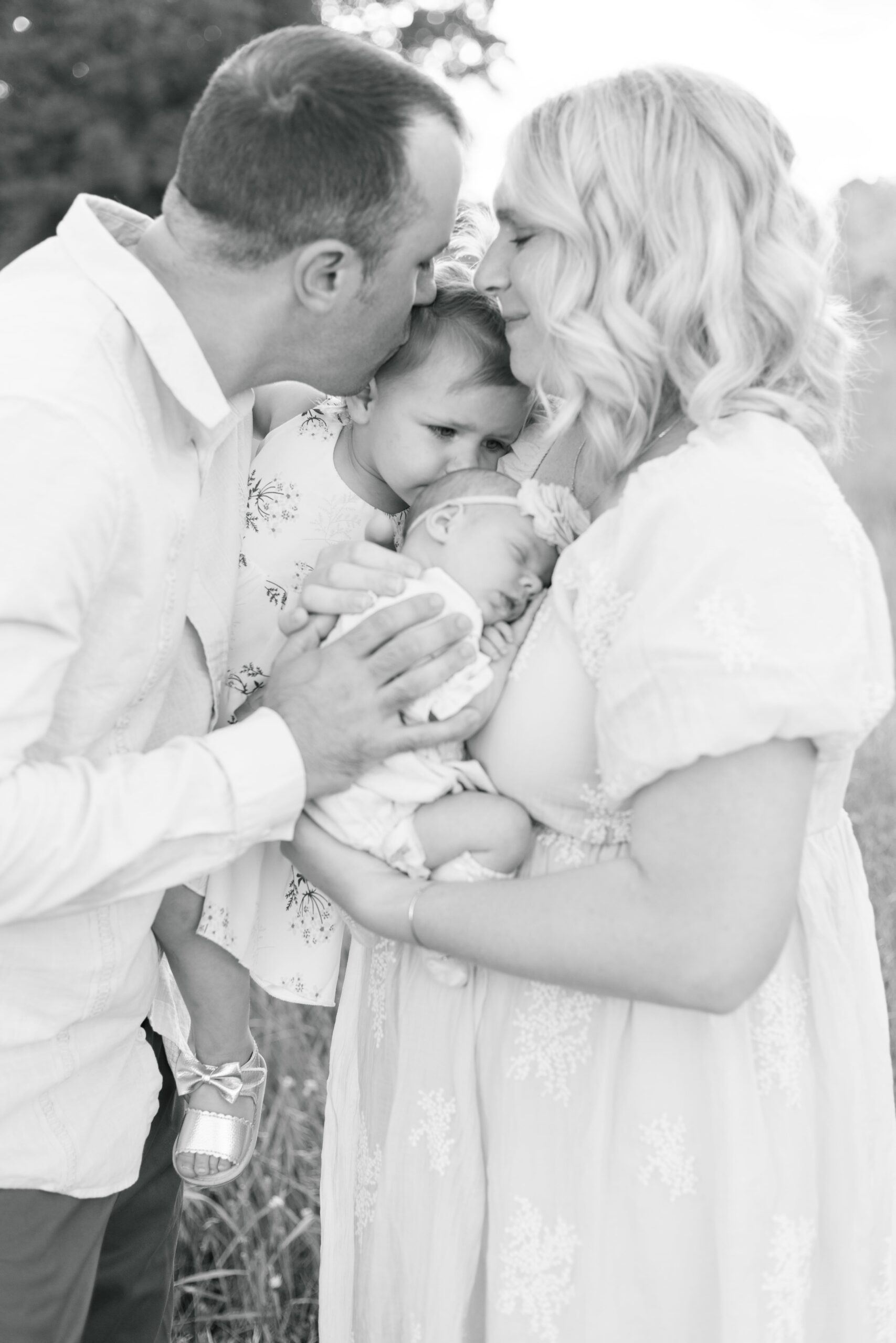 family kissing baby in peoria illinois newborn photos