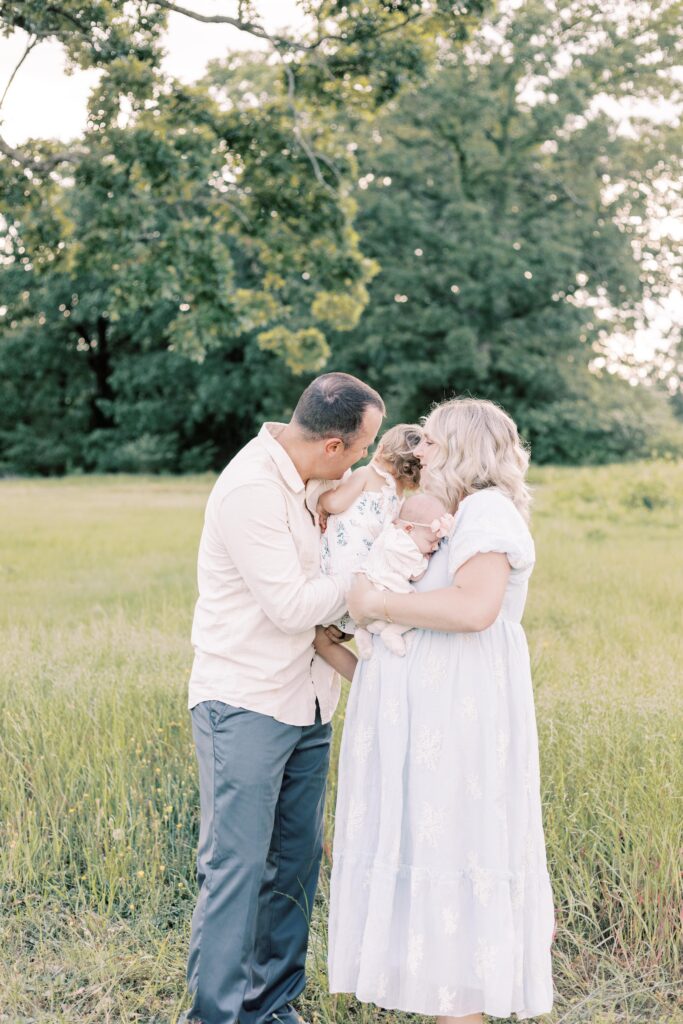 family hugging both children during baby photos in peoria illinois