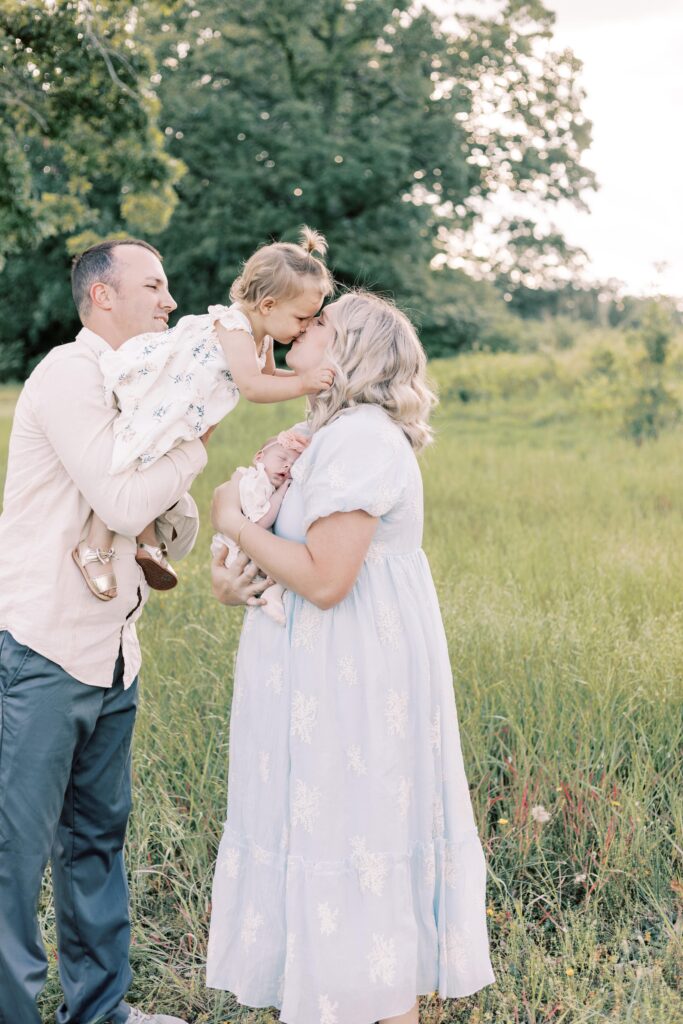 daughter leaning over to kiss mom in peoria illinois newborn photos