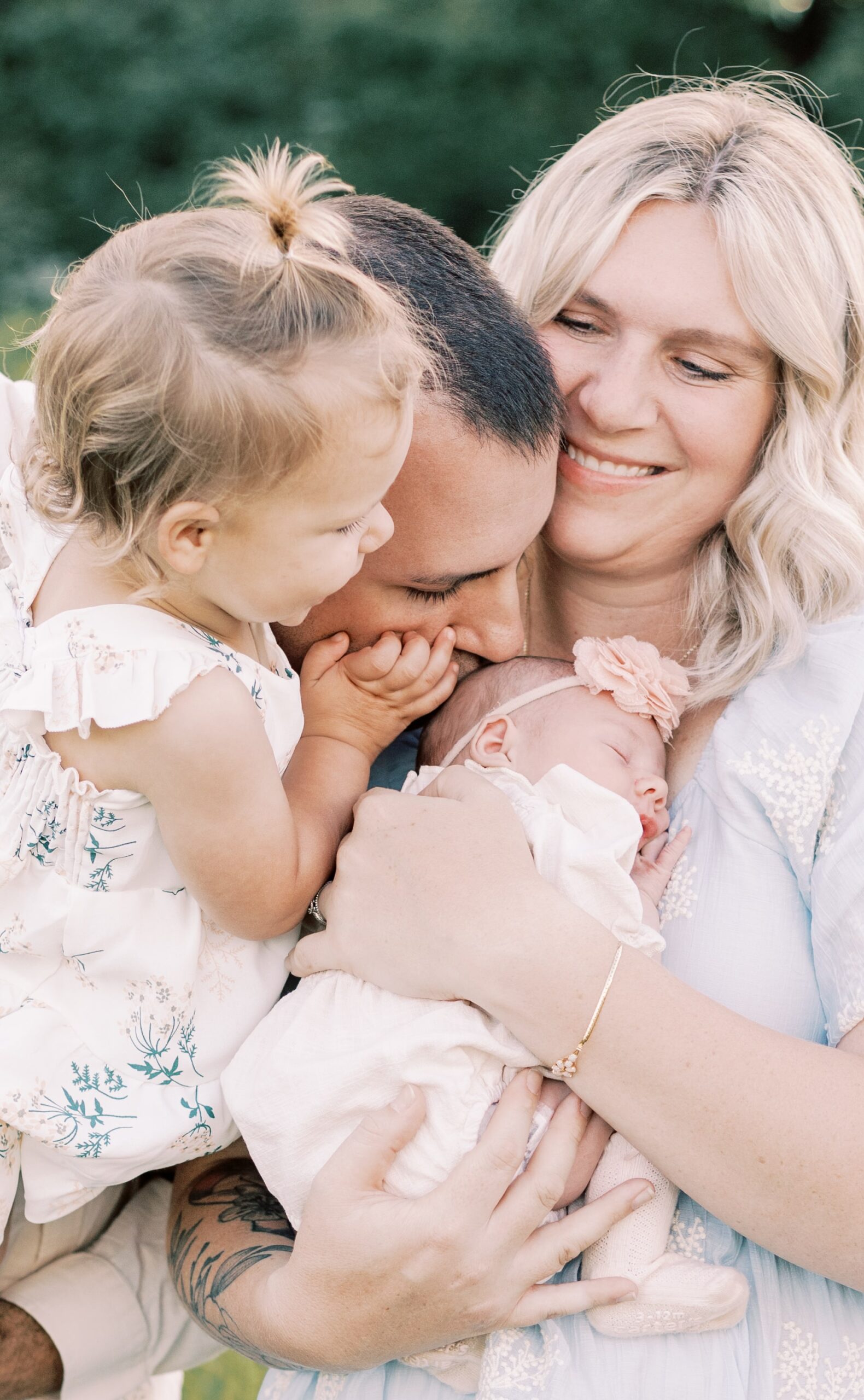 family snuggling close to give baby a kiss in newborn photos in peoria illinois
