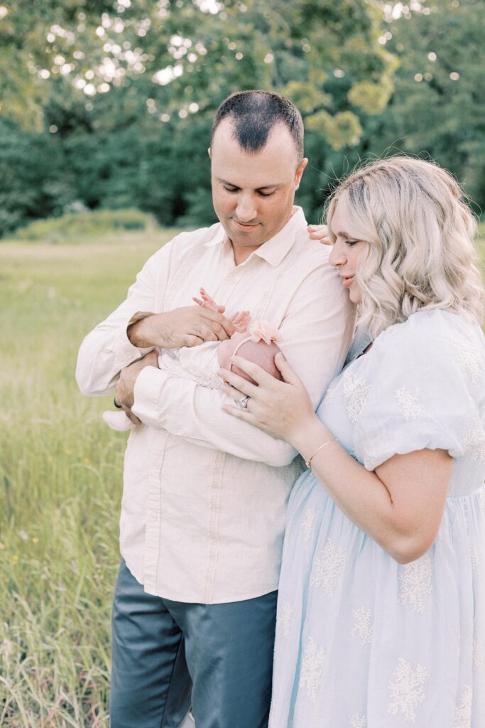 dad holding baby, mom looking at baby in peoria illinois newborn photos.