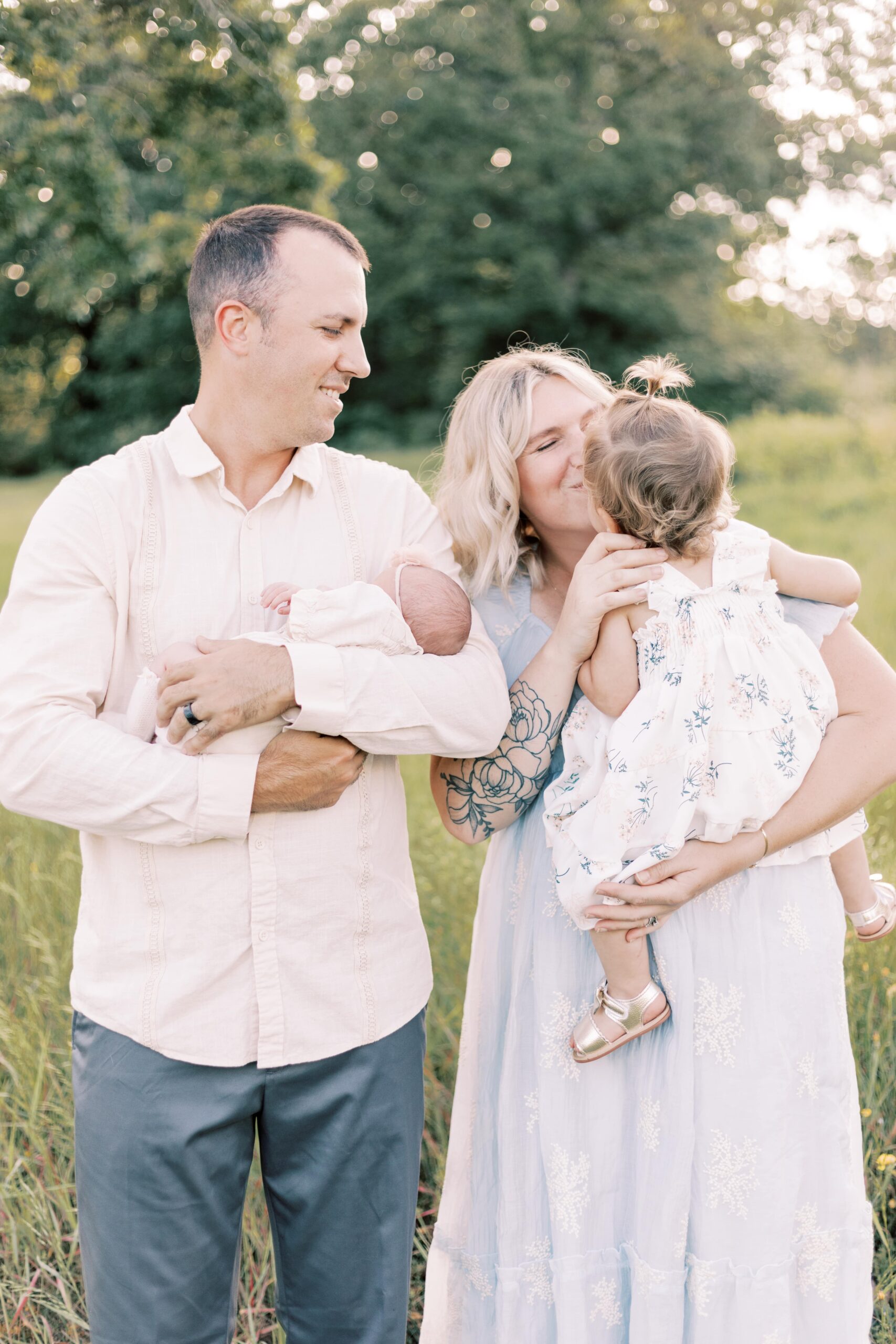 dad holding baby, mom kissing baby in peoria illinois newborn photos