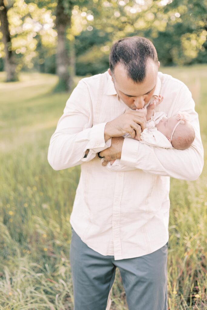 dad kissing baby's hand in peoria illinois newborn photos
