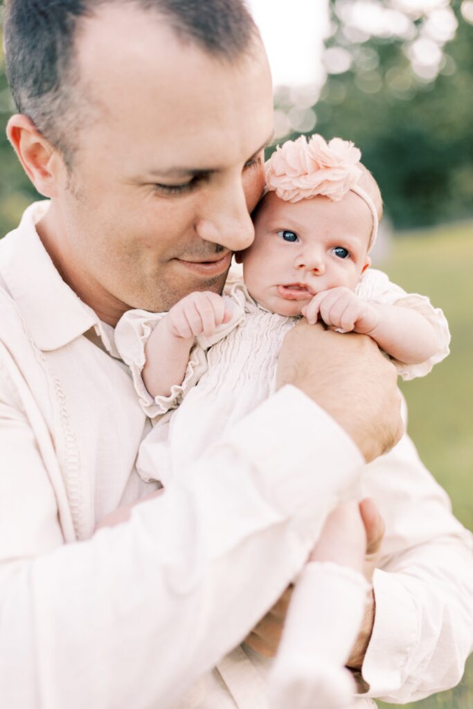 dad holding up baby daughter in baby photos peoria illinois