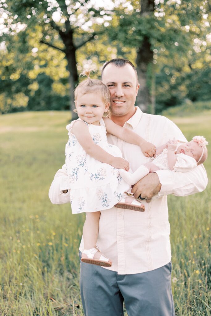 dad holding both daughters in central illinois newborn photos