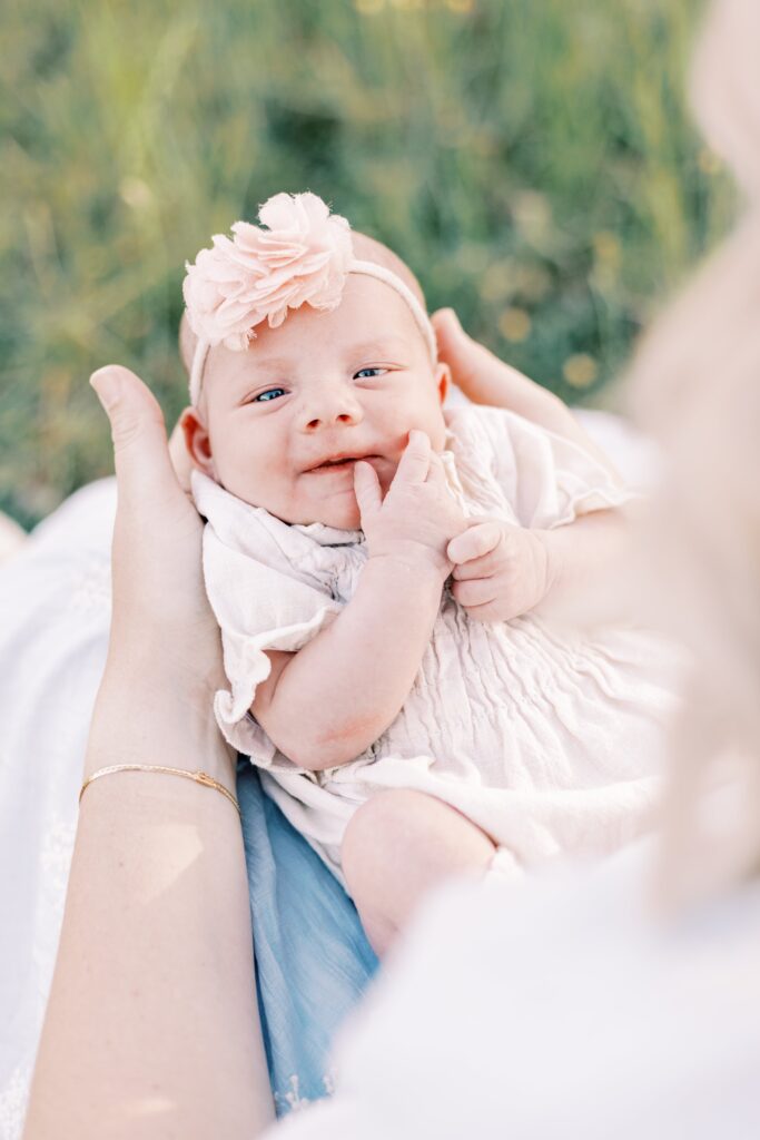 newborn baby on mom's lap smiling in newborn photos central illinois