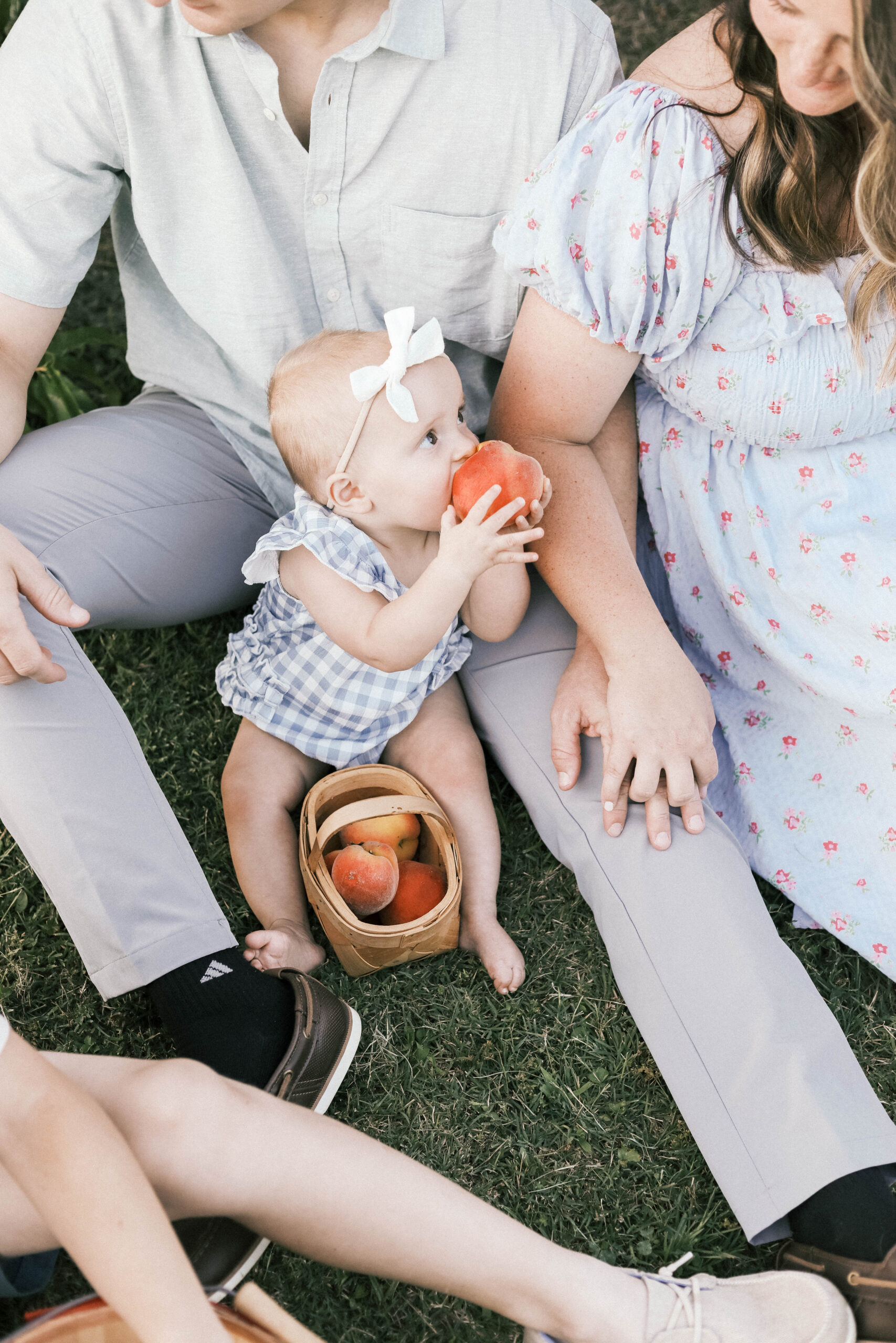 baby sitting and eating peaches with family