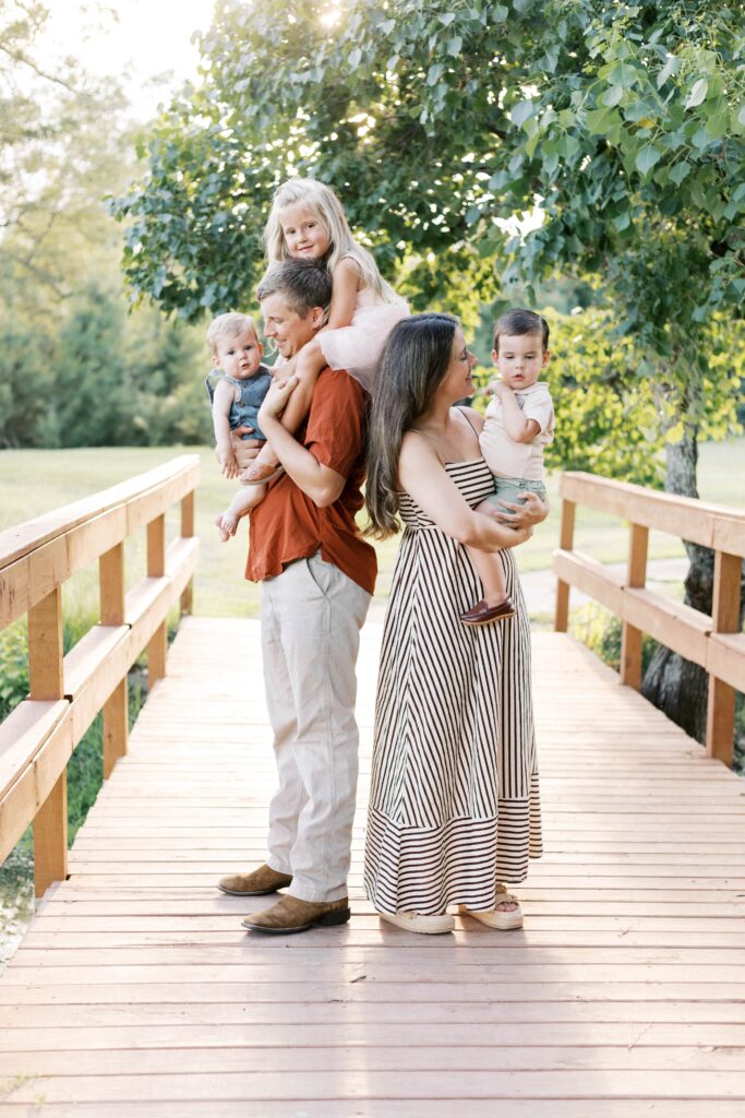 family standing on a bridge during summer sunset photos in peoria il