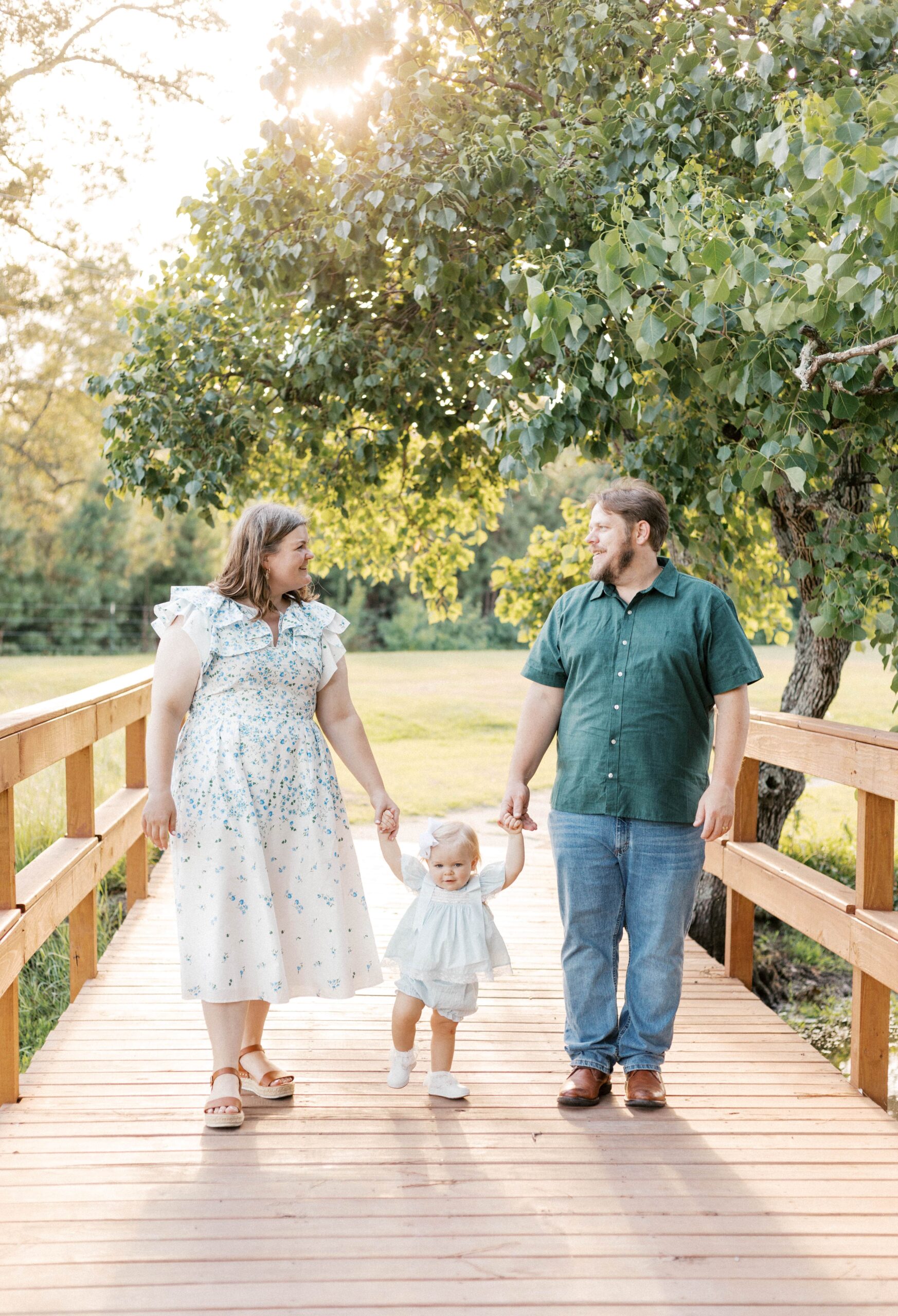 family walking with baby during sunset over a bridge
