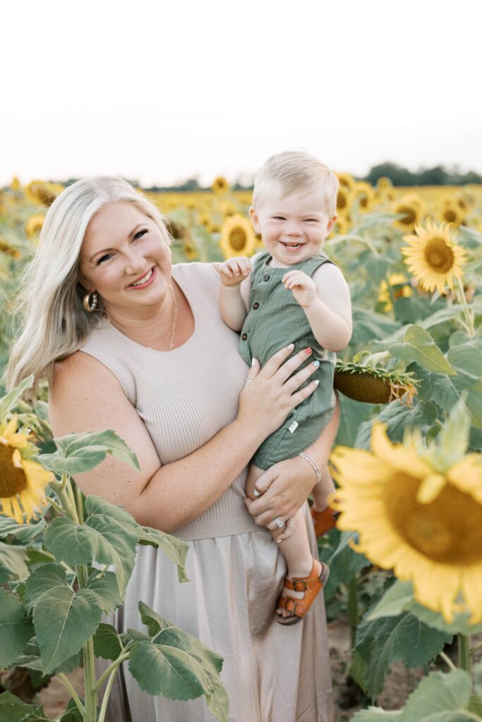 mom and baby smiling during sunflower field photos in peoria il