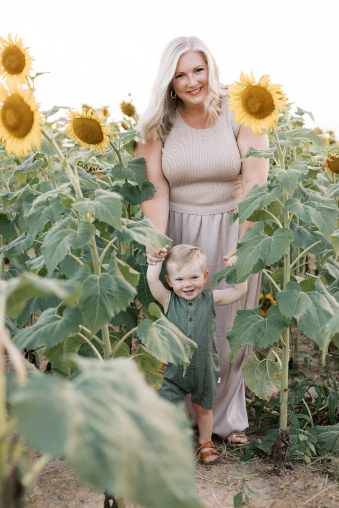 mom and son walking through sunflower field in peoria il family photos