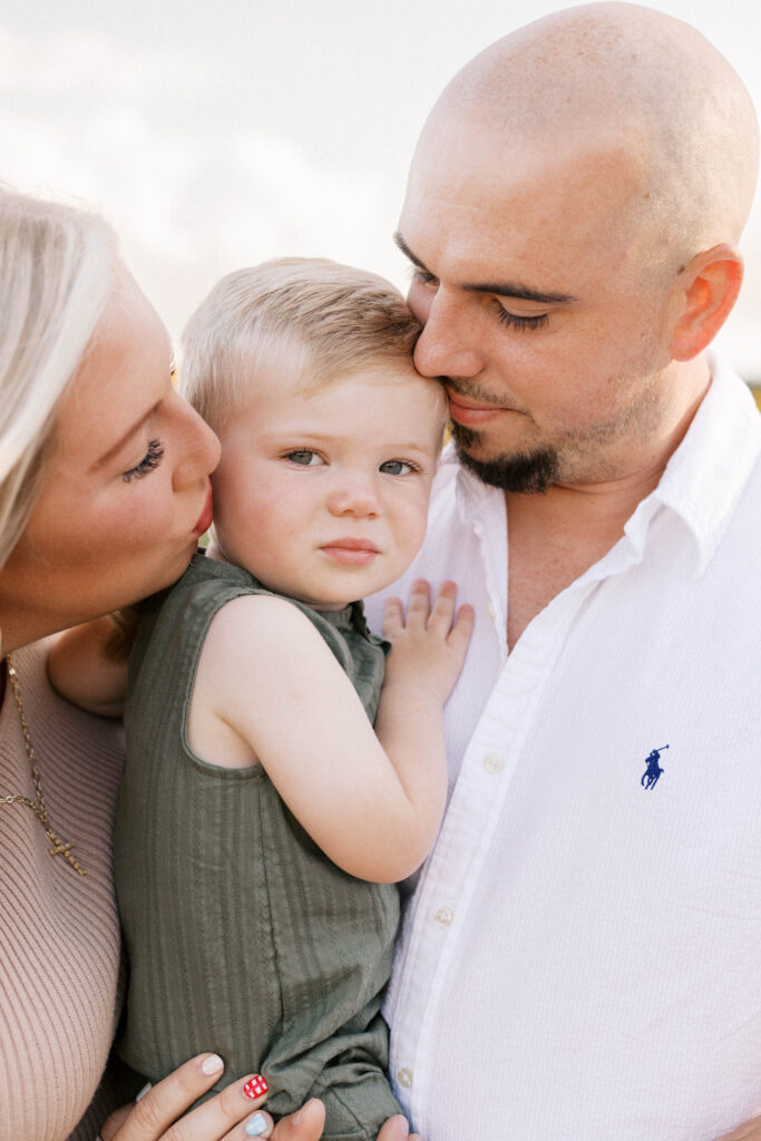 parents hugging baby in family photos