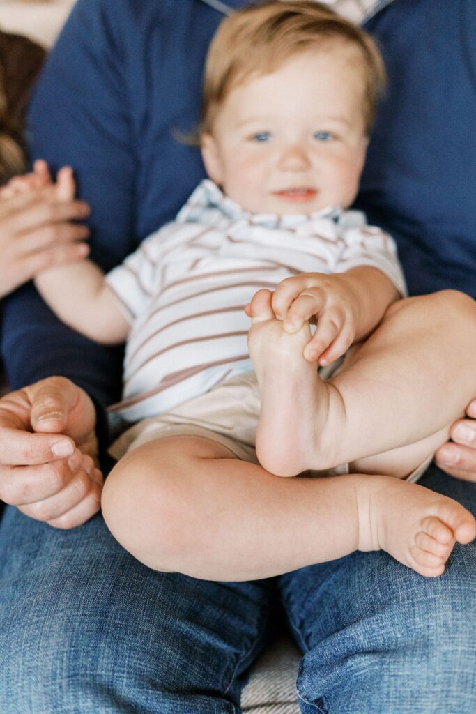 baby holding foot in one year milestone photo peoria il
