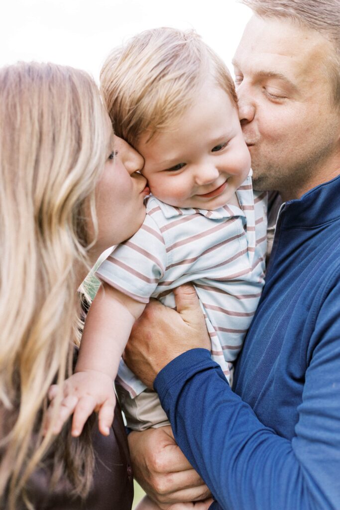parents kissing baby's cheeks in family photos peoria illinois