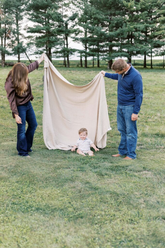 parents playing with baby blanket in peoria illinois family photos