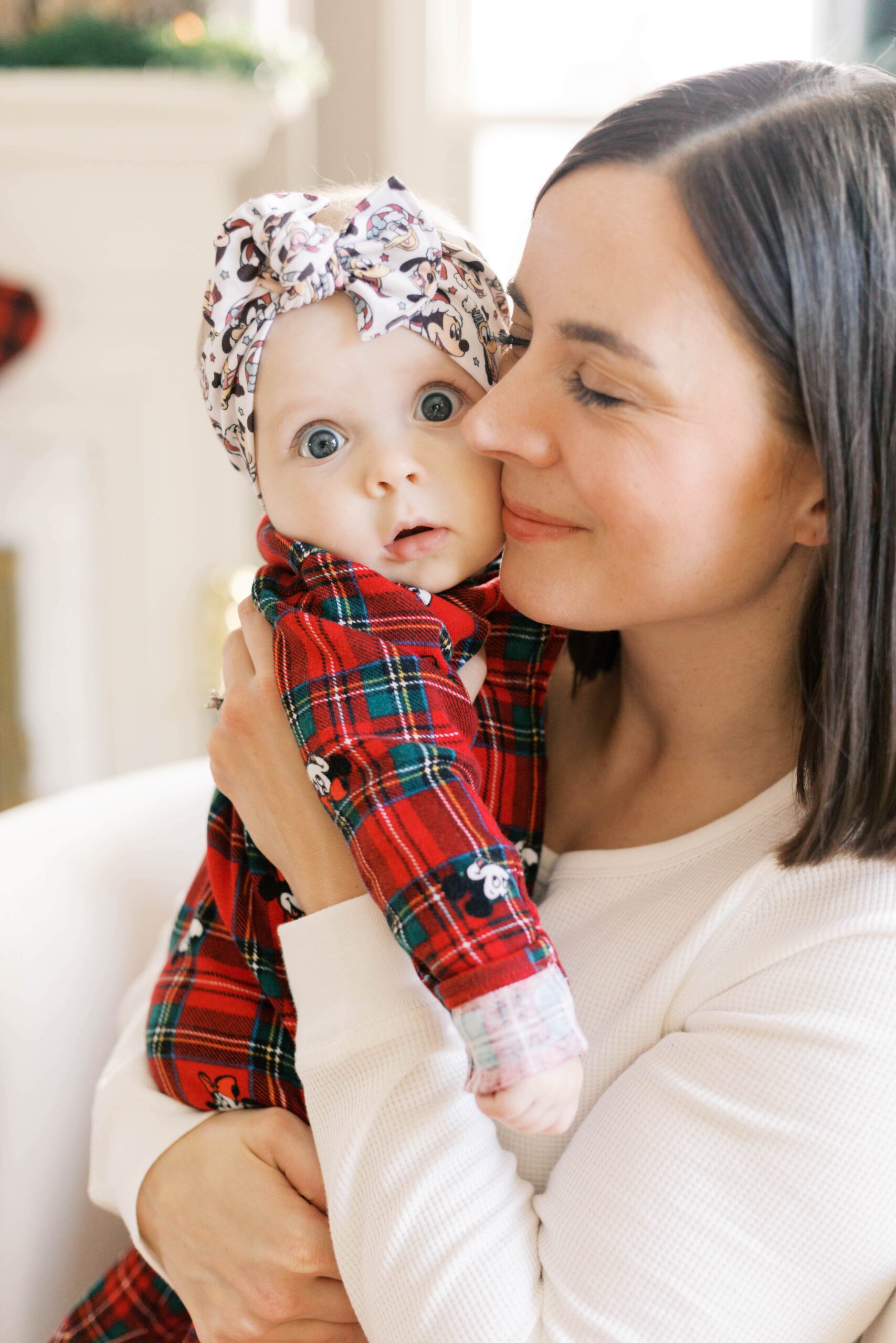 Parents holding baby near Christmas tree for Peoria IL Christmas photos