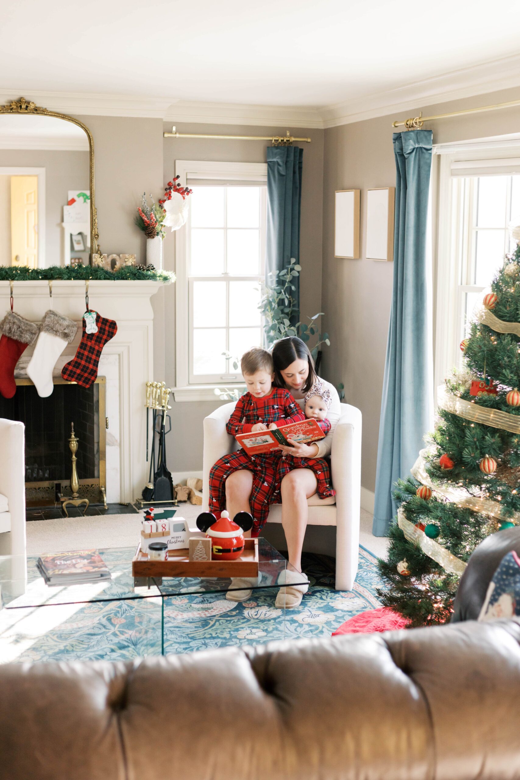 Parents holding baby near Christmas tree for Peoria IL Christmas photos