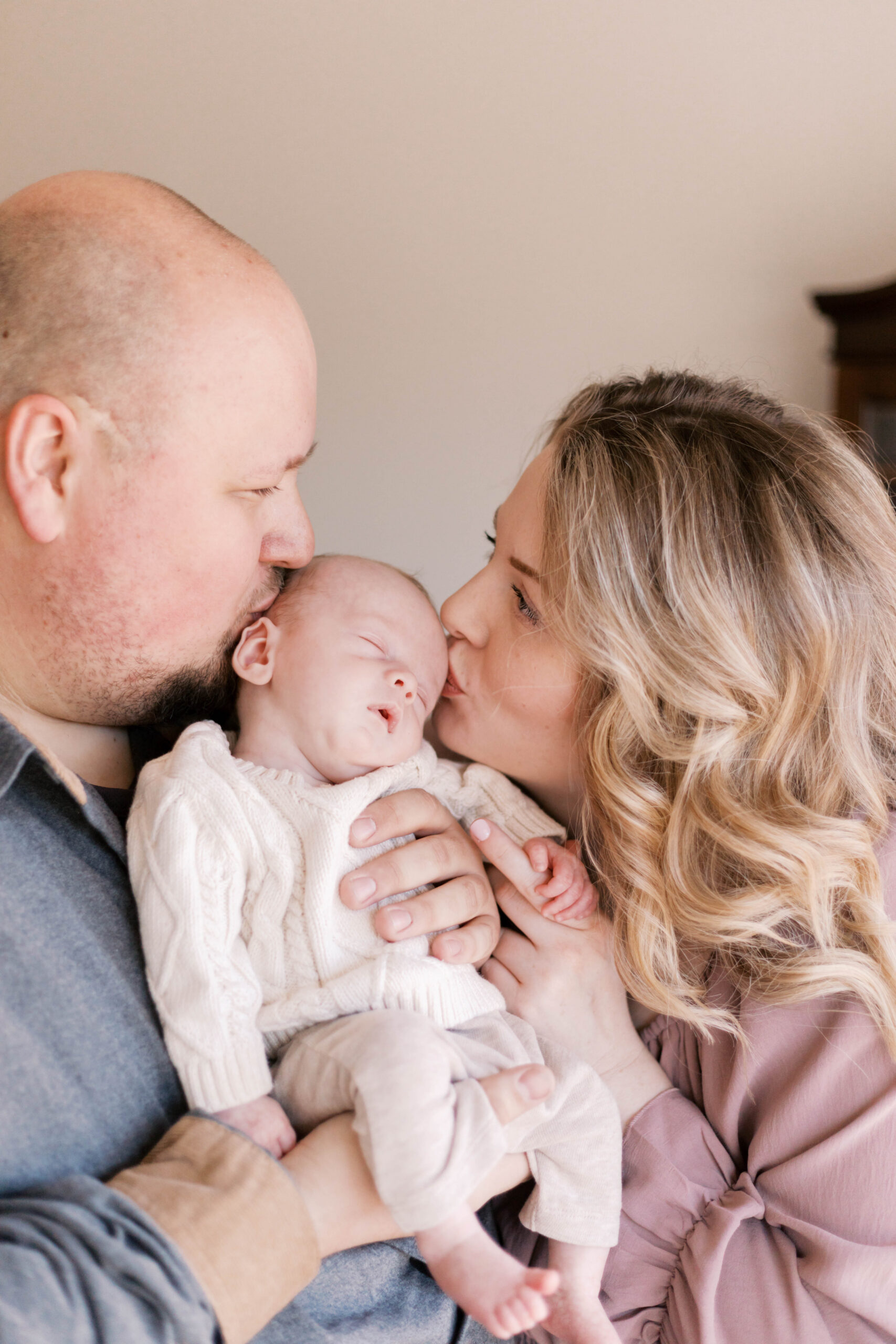 mom and dad kissing baby in in-home newborn photos in peoria il