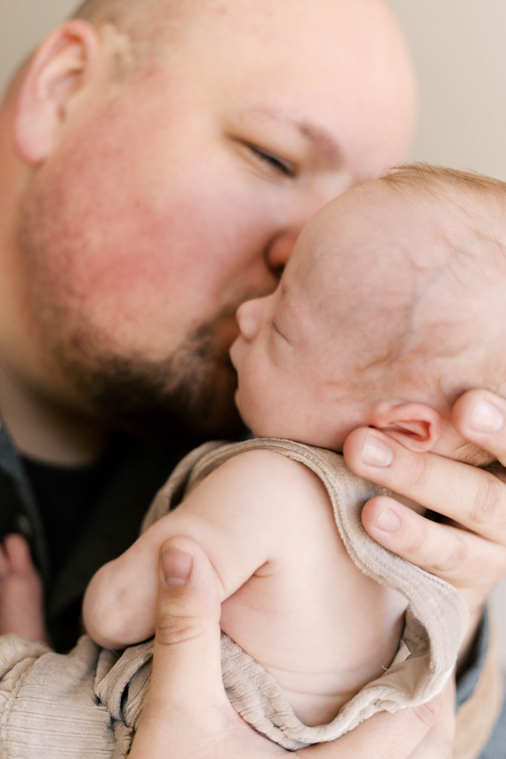 dad kissing newborn son during in-home baby photos in peoria il