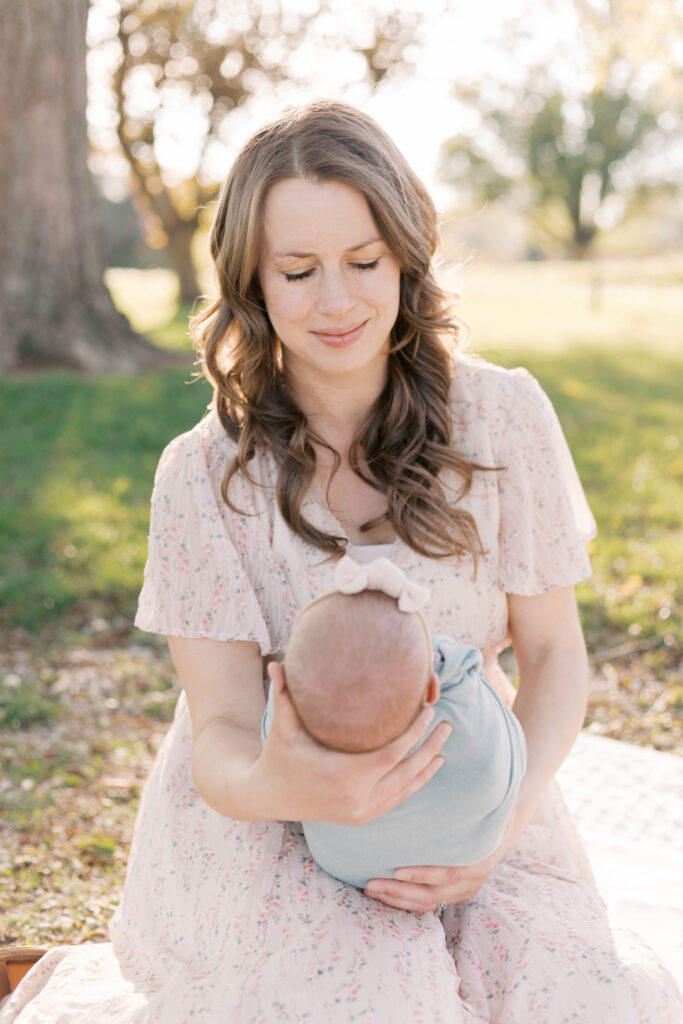 newborn photographer peoria il -27 mom looking at swaddled newborn baby in summer outdoor newborn photos in peoria il