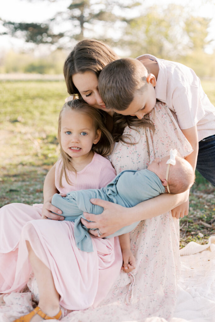 newborn photographer peoria il -54 mom hugging her children during newborn photos in peoria il