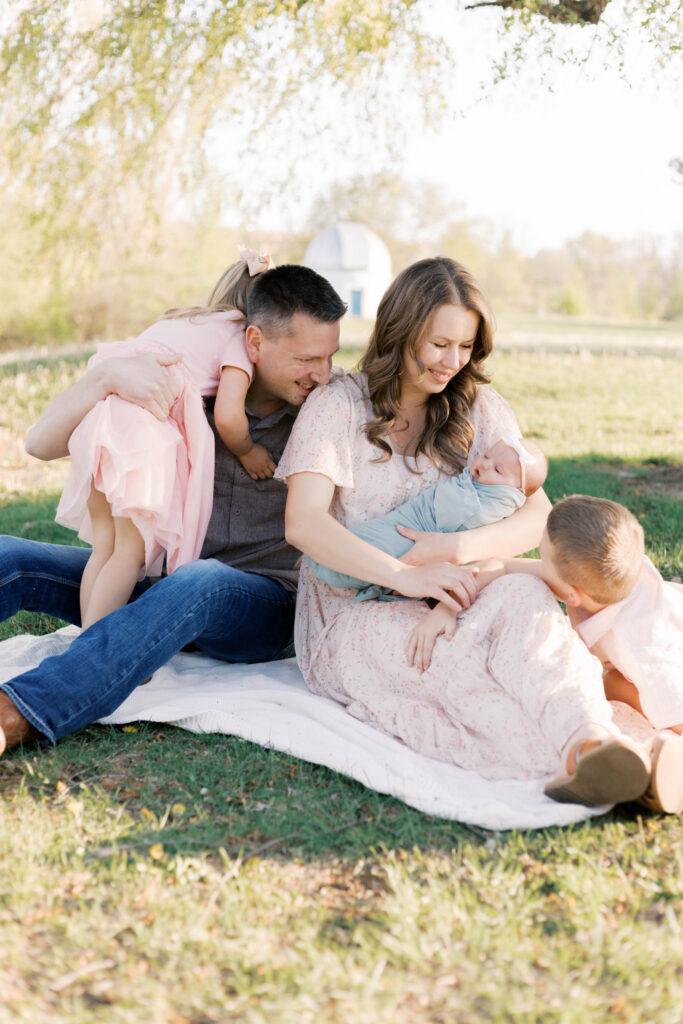 newborn photographer peoria il -87 family sitting with mom looking at son smiling during newborn photos in peoria il