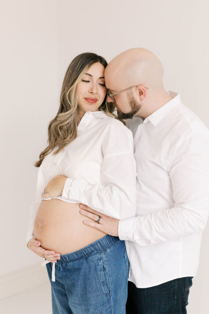 studio maternity photographer peoria il-13 pregnant mom and husband smile at each other in studio maternity photos in peoria il
