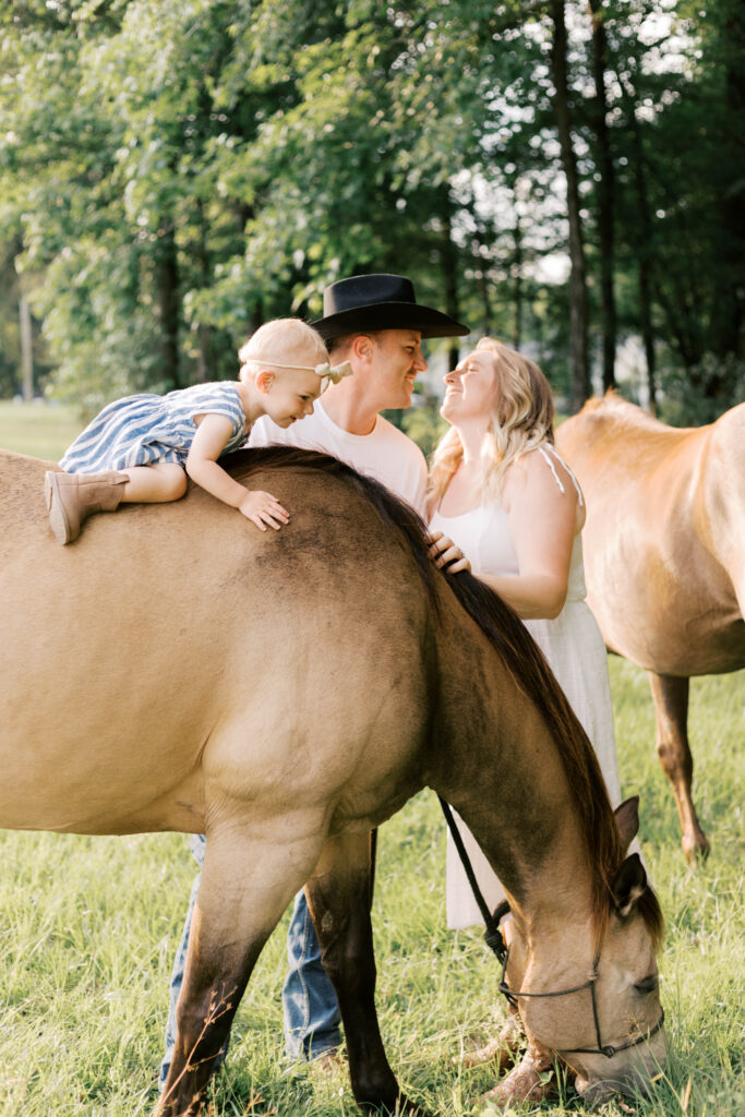 parents smiling while daughters are on horse in peoria il family photos