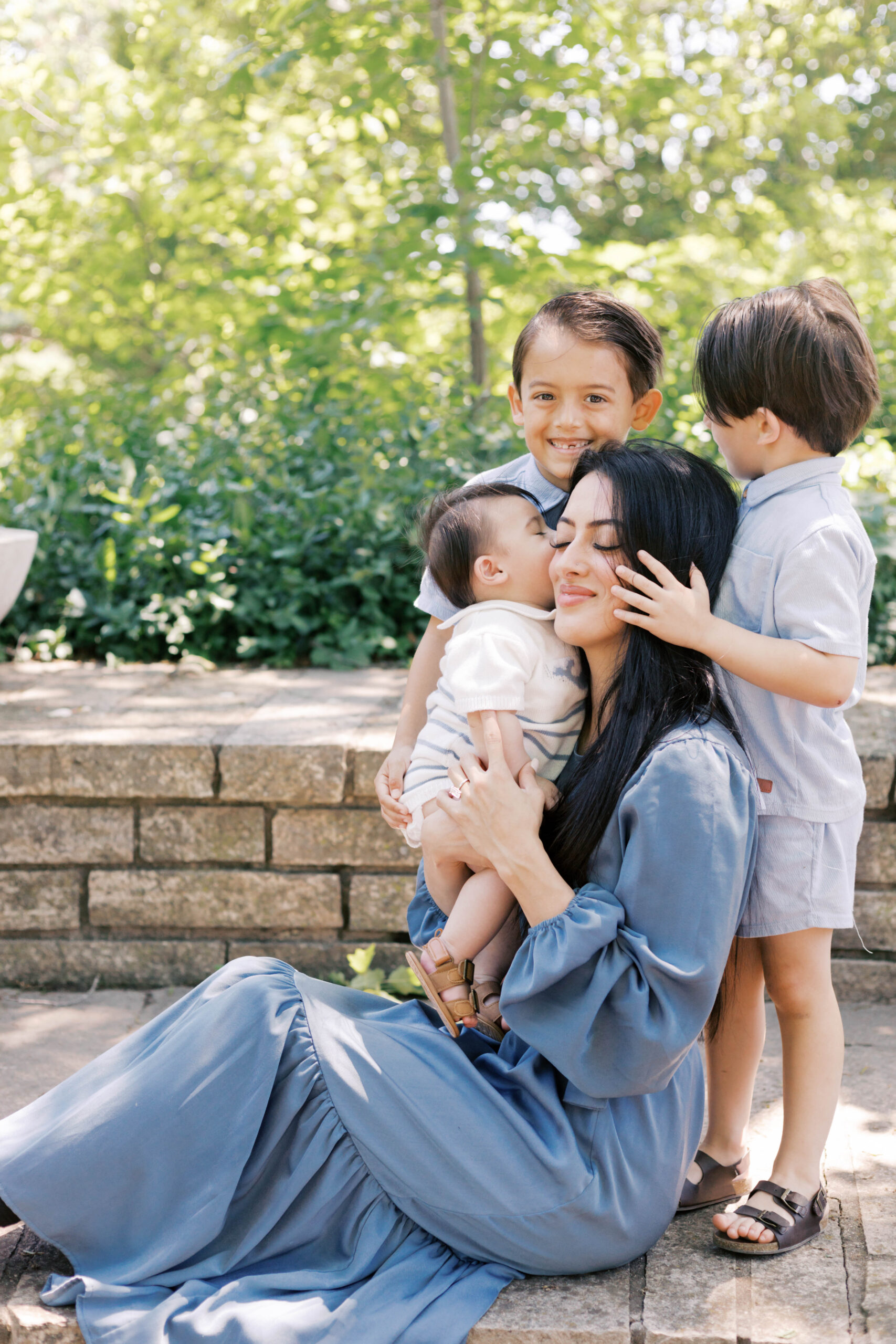 mom hugging her children in family photos in peoria il at luthy botanical gardens