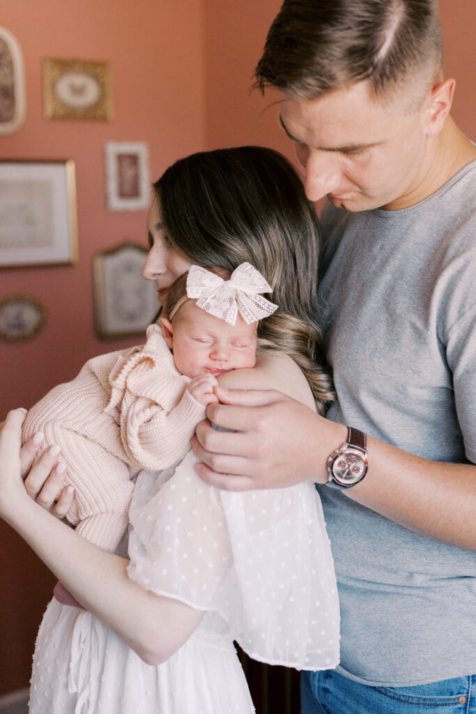 parents standing in nursery with sleeping baby in newborn photos in peoria il