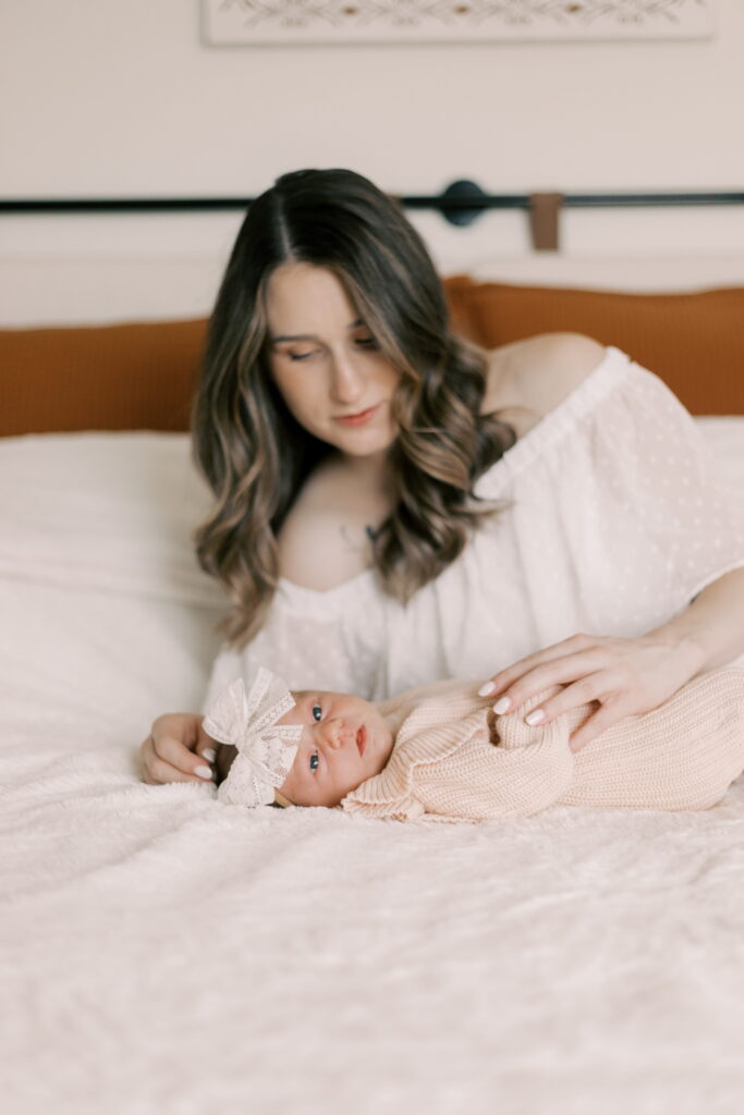 mom with newborn baby on the bed in peoria il newborn photos