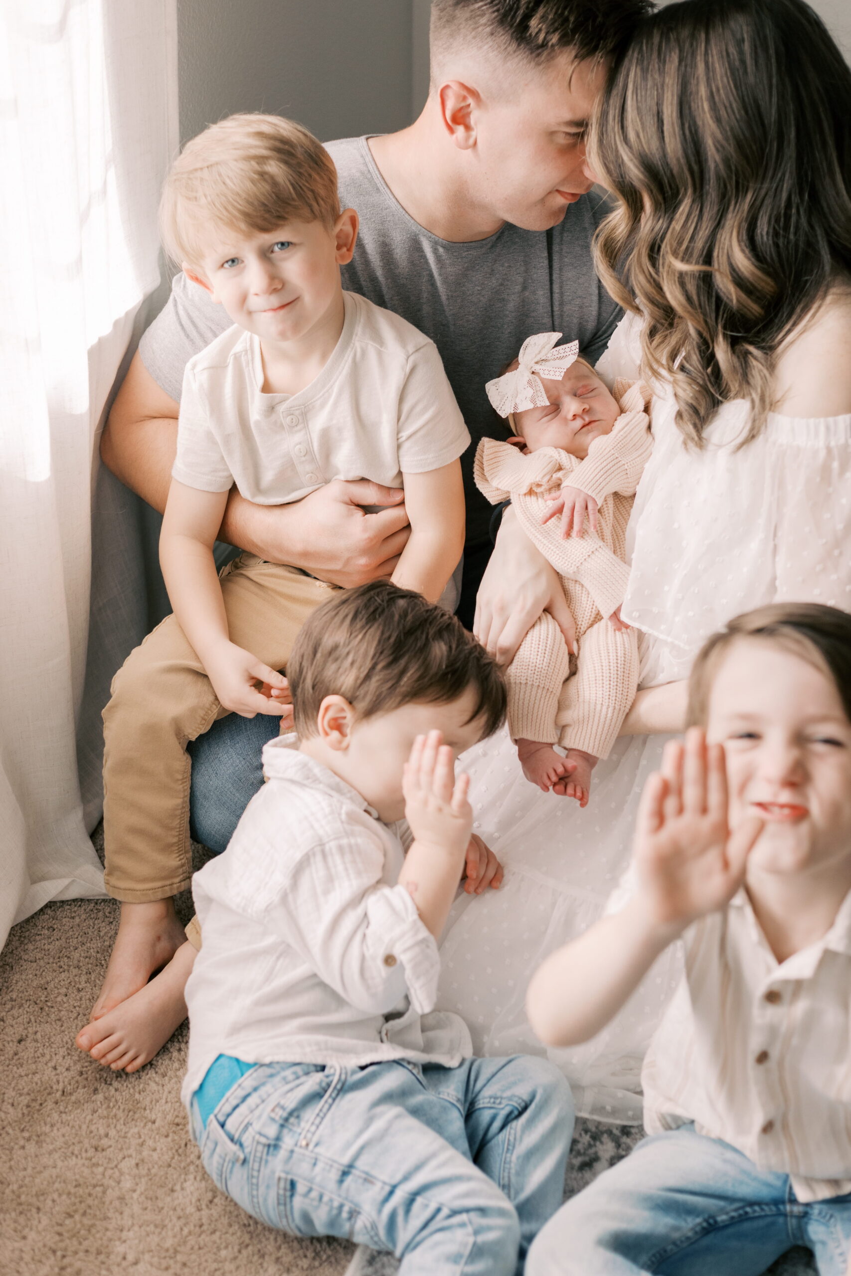 family sits in home with newborn baby in peoria il newborn photography